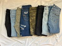 Eight folded jeans showing colours and washes