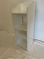 Full view of white shelving unit front and side