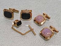All items: two cufflink pairs and tie tack displayed on textured surface