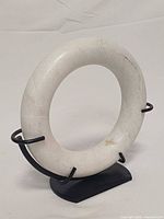 front view of marble ring sculpture on stand