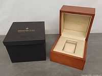 wooden box open beside black outer box