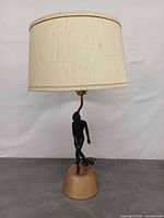 Full view of lamp with shade, figure, base, cord