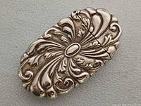 Front view of ornate silver-plated match safe