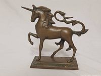 Left side view of brass unicorn statue