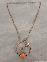 Full view of necklace laid flat showing pendant and entire chain