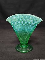 Front view of green opalescent hobnail fan vase on pedestal foot