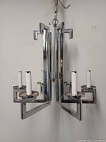 Chandelier front view showing geometric chrome frame and six candle sockets