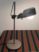 Lamp illuminated, side view showing adjustable mechanism and base