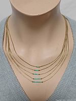 Necklace on bust showing five strands with turquoise accents