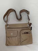 Front view showing pockets, strap, hardware