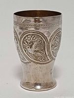 Front view of silver-plated beaker showing embossed bird panel