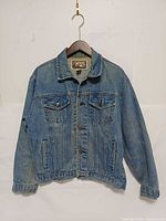 Front view of denim jacket on hanger