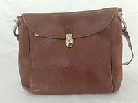 Front view showing flap, clasp and embossed logo