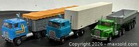 Three die-cast tractor-trailers side by side