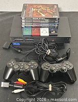 Full lot overview showing console, controllers, cables, memory cards and game cases.