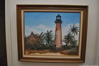 Framed lighthouse coastal landscape painting on wall