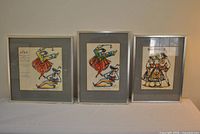 Front view of three framed artworks side by side