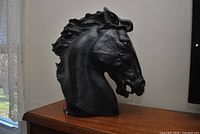 Left profile of black horse head bust on wooden surface