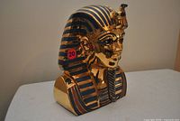 Front left view of metallic gold King Tut ceramic bust on table