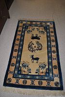 Full view of area rug showing design, colors and fringe