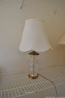 Full view of crystal and brass table lamp with shade