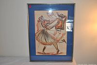 Front view of framed artwork showing dancers, blue mat, metal frame