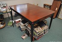 Full view of dining table showing brown top, black base, drawers