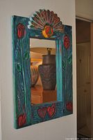 Front view showing carved wood frame, mirror glass and decorative motifs