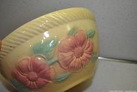 Side view showing floral relief detail and rope rim