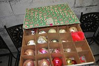 Open top layer of box showing compartmented vintage glass ornaments