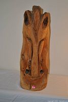 front view of carved wooden horse head showing facial detail