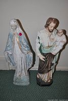 Front view of both plaster statues showing size, paint colors and wear