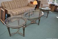 Set of three matching metal and glass tables positioned in living room