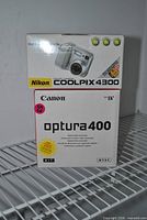 Stacked view of Nikon Coolpix 4300 and Canon Optura 400 boxes