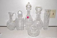 Front view of all six clear cut and pressed glass pieces lined up