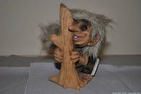 Front view of NyForm troll hugging tree stump with tag visible