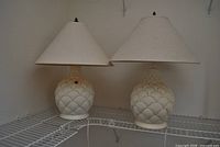 Pair of matching ceramic table lamps with fabric shades on shelf