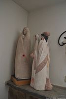 Two ceramic figurine sculptures displayed on mantle