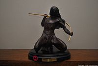 Front view of bronze sculpture on base with bow drawn