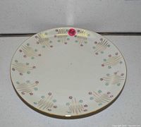 Top view of porcelain plate showing starburst pattern and gold rim