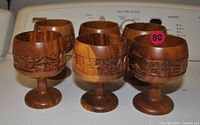 Set of six carved monkey pod wood goblets on washer top
