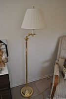 Full view of brass floor lamp with pleated shade showing height, base, swing arm, and overall condition