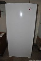 Front view of white Whirlpool upright freezer