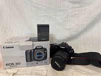 Front view of camera with lens, charger and box