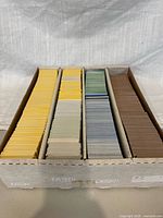 Open storage box showing four sorted rows of baseball cards with color-coded groups