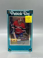 Front of card inside teal screw-down case with price sticker visible