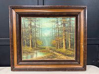 front view of framed forest landscape painting
