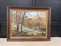 Front view of framed oil painting showing landscape scene and frame details