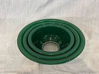 three green Pyrex bowls nested