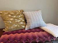 Overall group shot showing both pillows, chevron afghan, cream throw